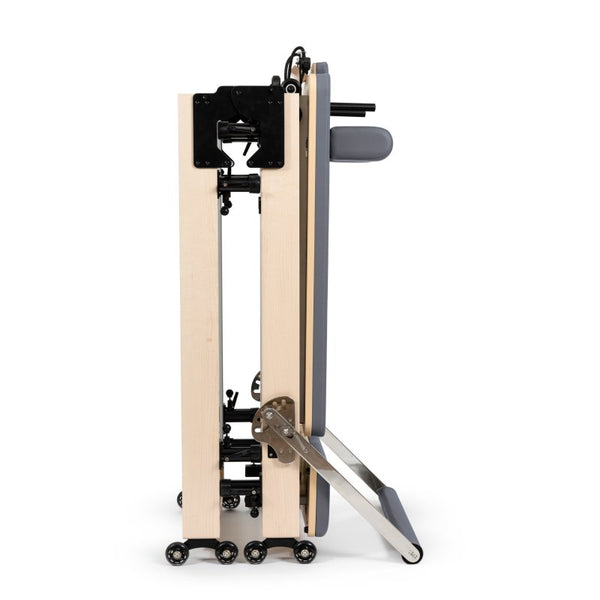Wooden pilates exercise machine with metal components on a white background